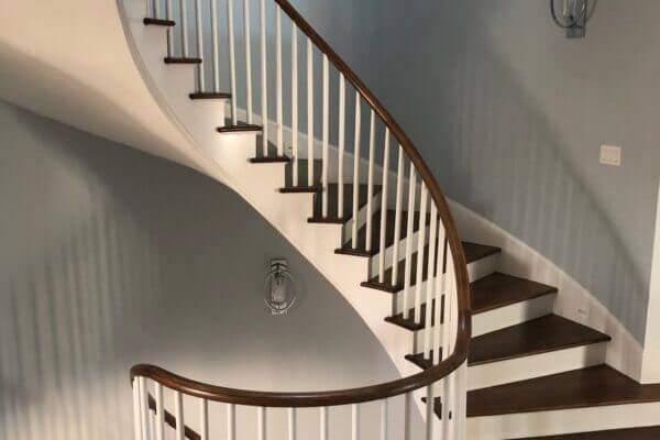 Stained and painted wooden circular staircase in a home