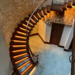 Curved wooden Staircase with floating wooden treads lit from below