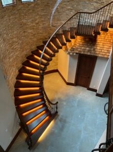 Curved wooden Staircase with floating wooden treads lit from below