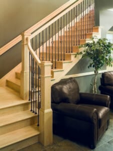 Mission style staircase with light colored wooden parts and iron balusters