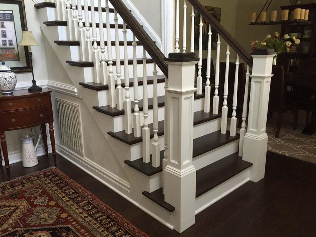 Landing of a craftsman style staircase with painted wood and red oak